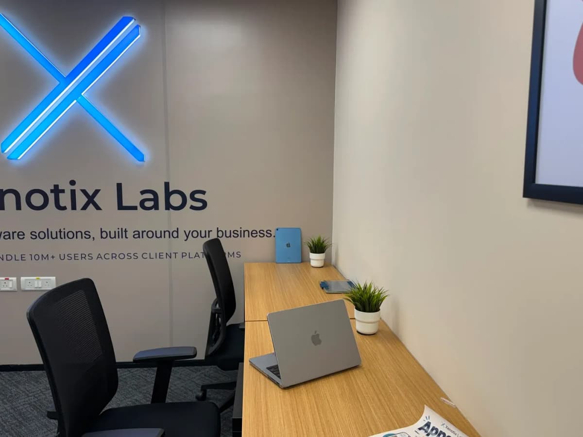Xenotix Labs backlit logo wall beside the work desks