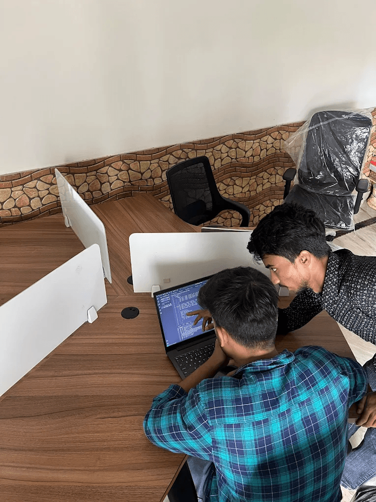 Xenotix engineers debugging code together — pair programming on a production issue