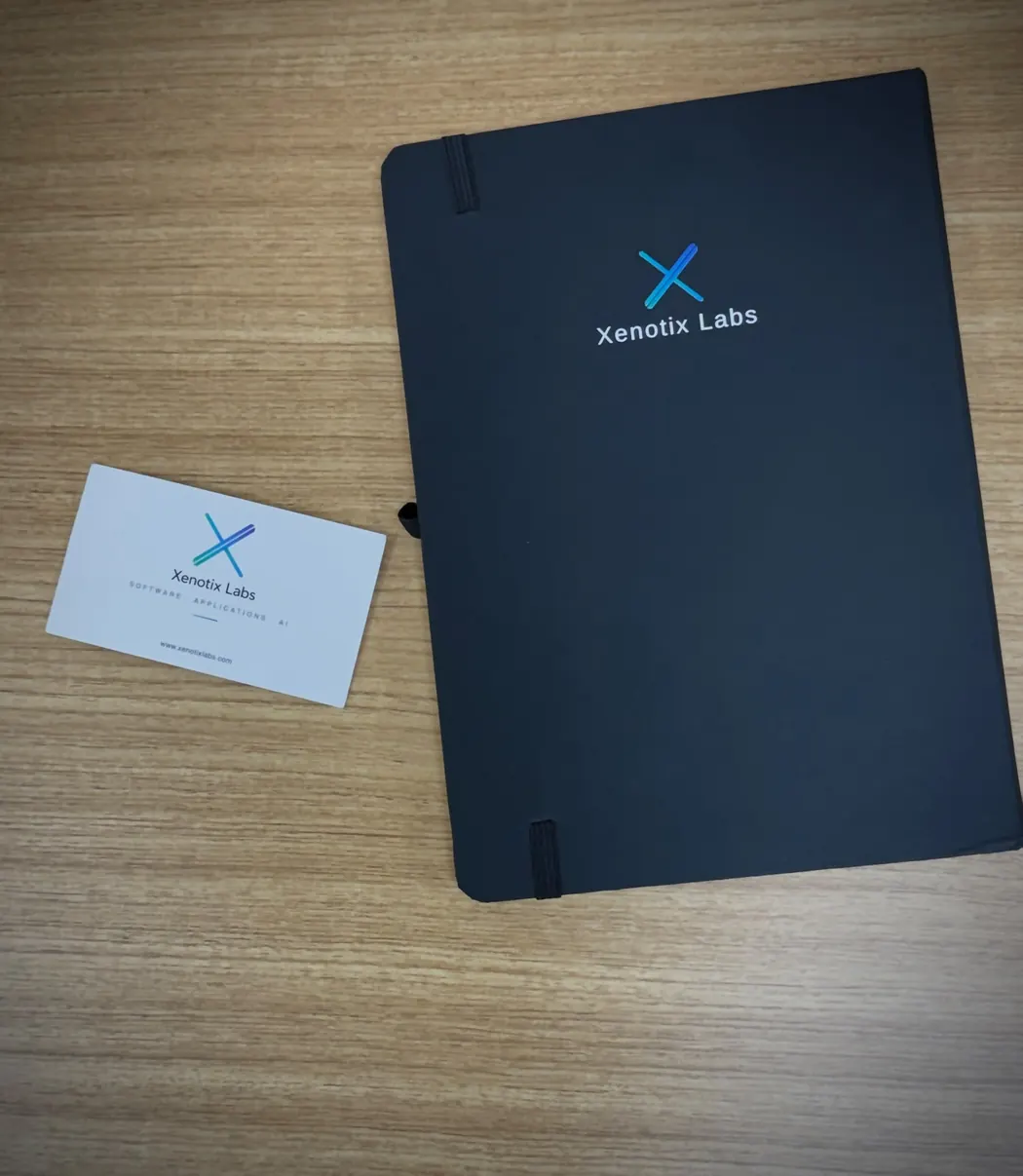 Xenotix Labs notebook and business card on a desk